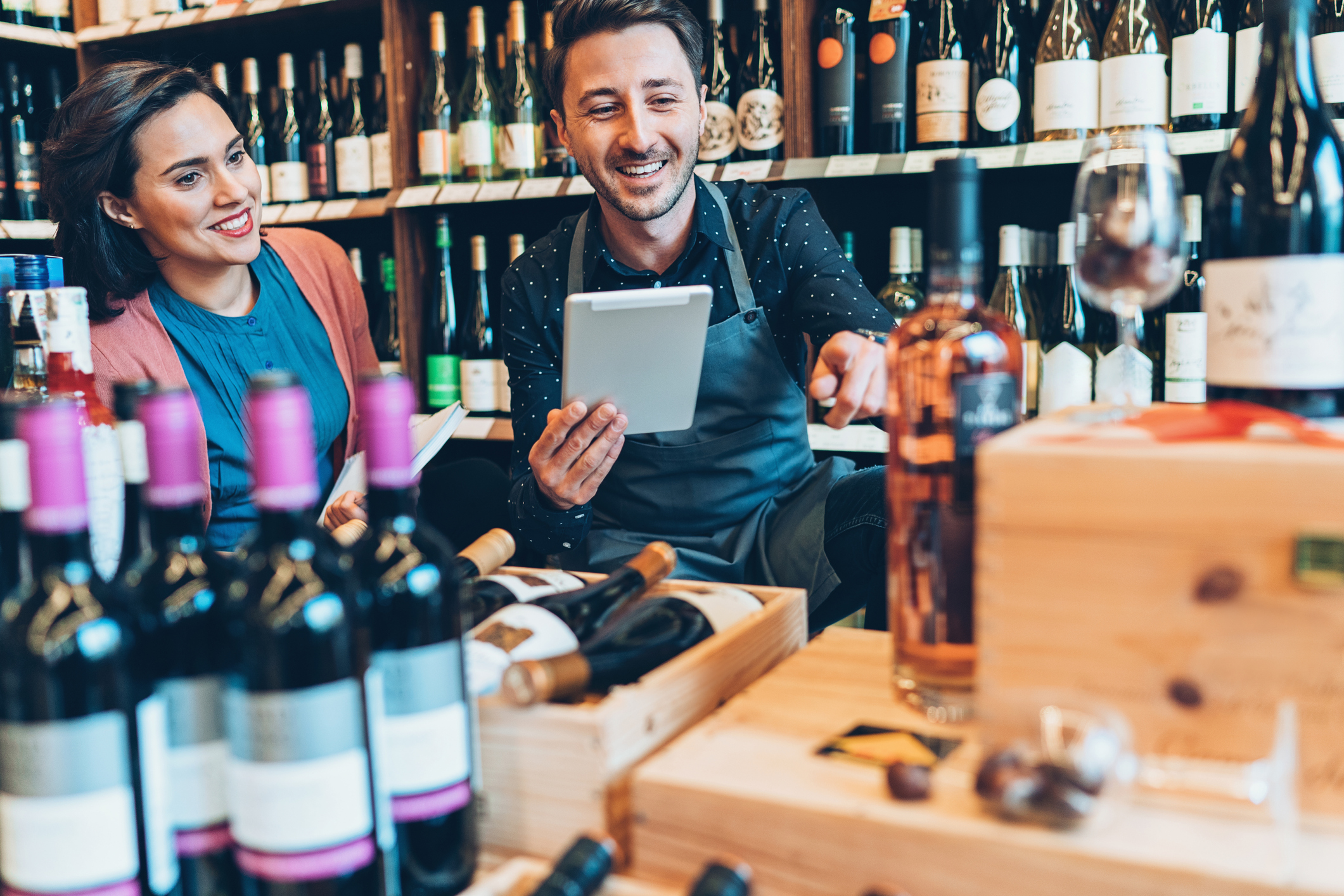 Winery workers taking inventory of wine bottles with wine inventory software