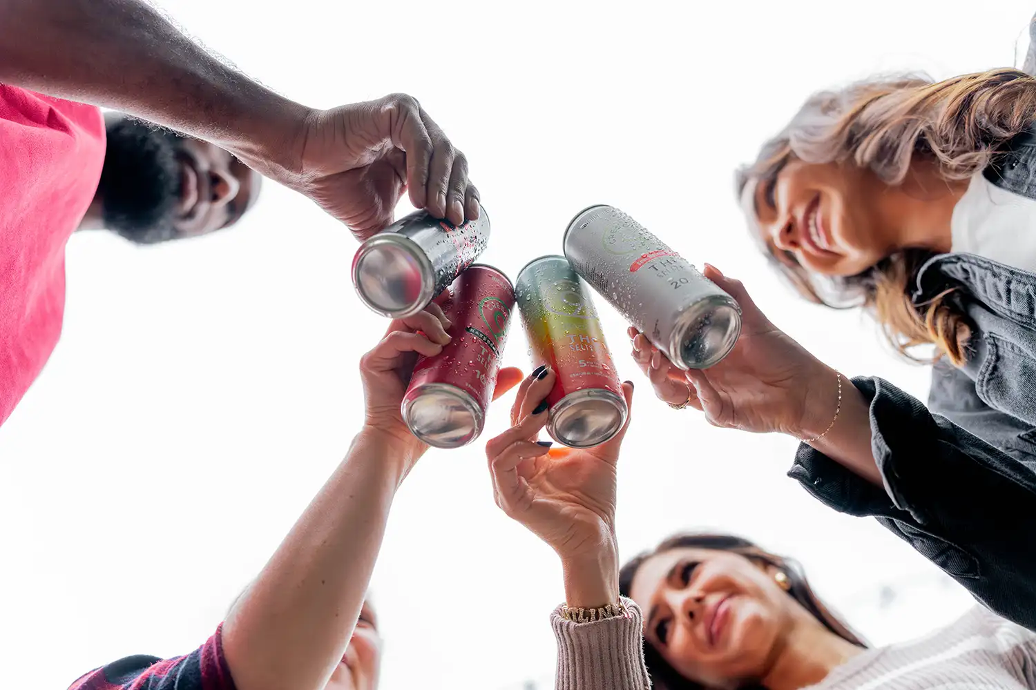 A group of people toasting cans of Crescent Canna THC beverages